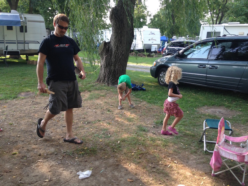 camping trip kids helping to pick up sticks for fire starter